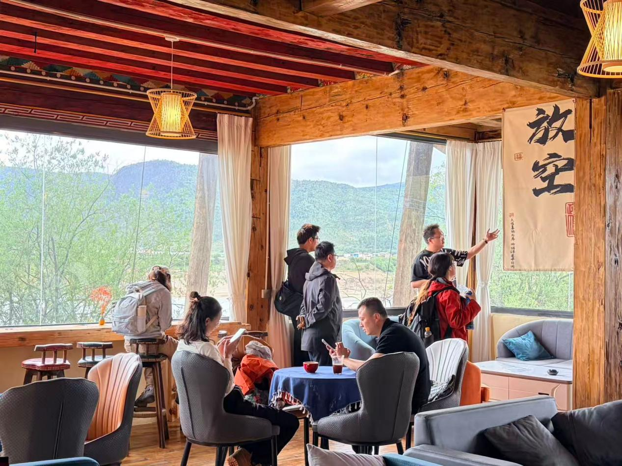 游客在鼐思·碧水蓝天乡村旅游景区休闲区内喝咖啡、赏风景